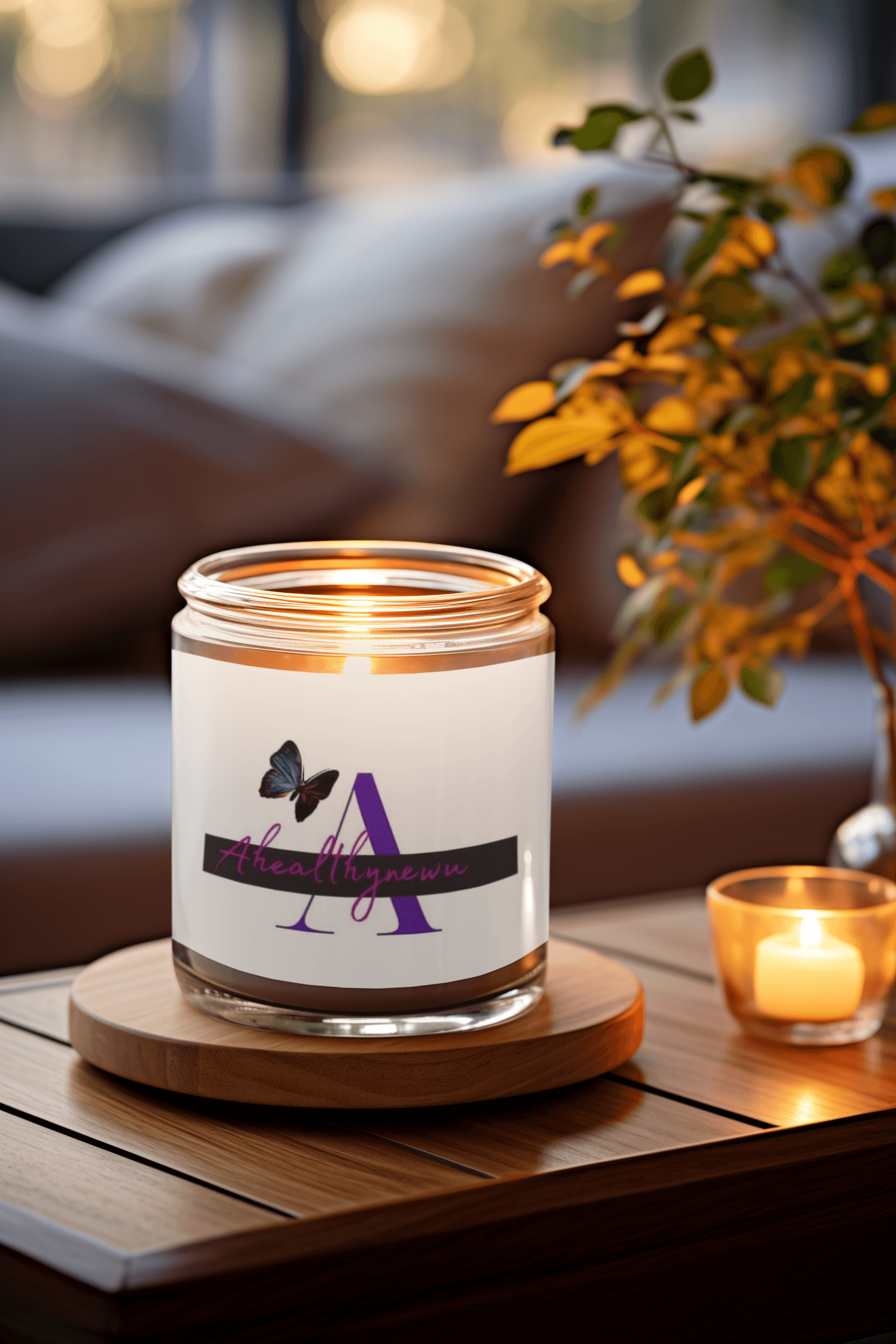Lit candle in a glass jar with a purple butterfly label on a wooden coaster.
